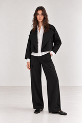 Mujer con Chaqueta Habla Negra corta oversize, camisa blanca y Pant Habla Negro cargo de bota ancha