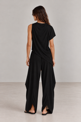 Mujer de espaldas con Blusa Asimétrica Negra drapeada de cuello alto y Pant MiaRoma Negro en look total black